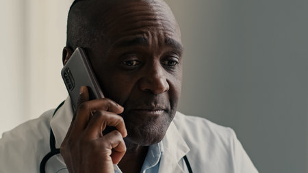 African American ethnic doctor man therapist medical worker consult patient by mobile phone male...