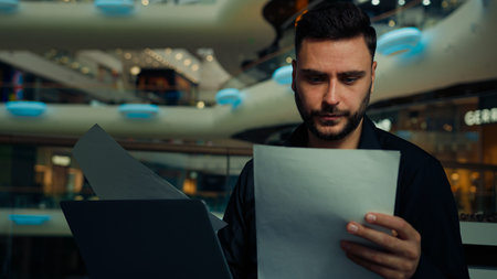 Male young businessman entrepreneur man doing corporate paperwork read business contract...