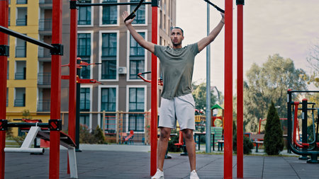 Powerful athlete african latina man sportsman strong guy doing legs exercise using weight TRX straps...