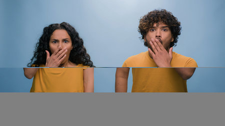 shocked scared afraid couple amazed shocked woman hiding behind man astonishment wonder scare...