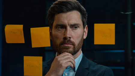 Thoughtful Caucasian businessman employee middle-aged man analyze information on stickers read...