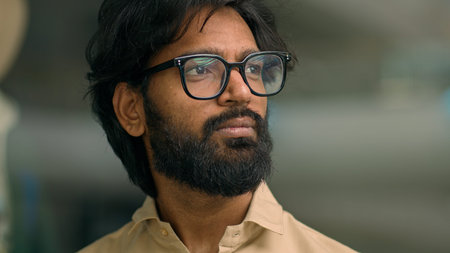 Serious thoughtful Arabian bearded man in glasses in office corporate company thinking looking away...