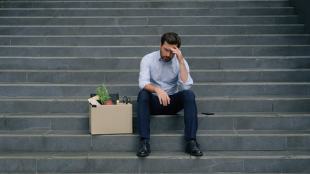 Business failure dismissed office leave sitting stairs Caucasian sad stressed businessman employer...