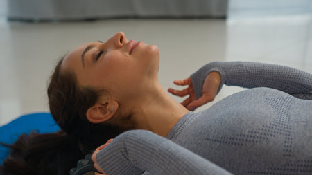 Caucasian woman relax female yogi girl sportswoman enjoy massage roller equipment for myofascial release healthy massaging rolling neck muscles health care physical therapy sport yoga training at homeの写真素材