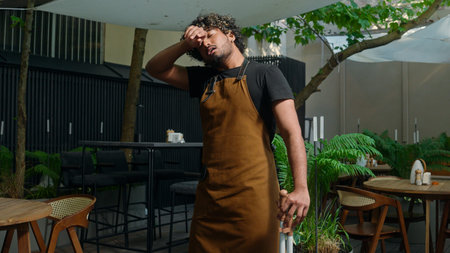 Tired exhausted ethnic male man guy in apron waiter cleaner barista street food worker sweeping dirt...