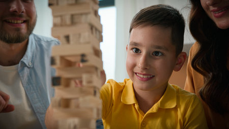 Close-up happy caucasian family mom dad son having fun playing Jenga caring parents play with beloved child boy in intellectual logical board game wooden puzzle spend weekend together enjoying gamesの写真素材