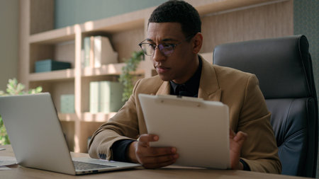 Business man African American accountant male office worker write financial data analysis plan...