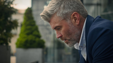 Pensive sad worried sorrowful thoughtful middle-aged man senior mature business employer businessman think ponder problem solution grief put on glasses dreaming contemplate thinking in city outdoorsの写真素材