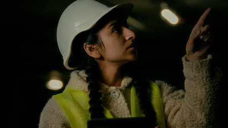 Young arabian woman technician inspector engineer developer wears protecting helmet uniform use...
