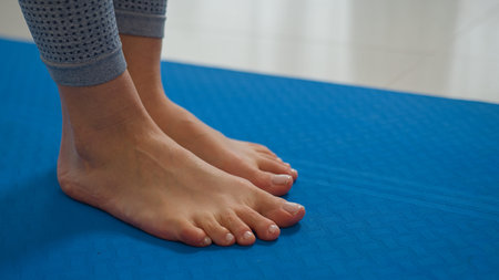 Close up female legs feet stand on gymnastic mat yoga class gym barefoot woman preparing start...