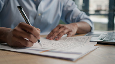Close up unrecognizable man businessman writing paperwork report on desktop male hands signing business documents on office table student write educational test english exam studying in universityの写真素材