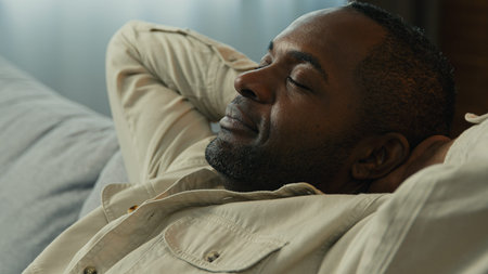 Headshot calm relaxed happy african american man relax resting on couch enjoying calmness sleepy...