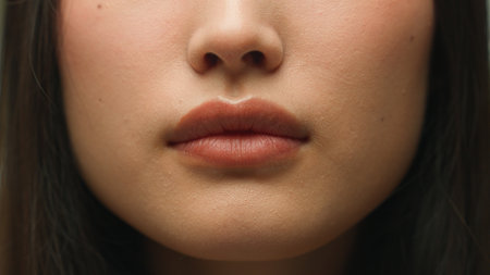 Extreme close up mouth female woman unrecognizable girl face details Asian chinese lady lips health care beauty procedure makeup cosmetics lipstick smile cropped shotの写真素材