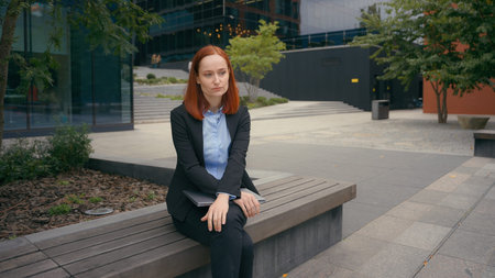 Sad businesswoman close laptop frustrated upset worried woman business crisis no idea mistake failure finish computer work sitting in city near office nervous employee stressed thinkingの写真素材