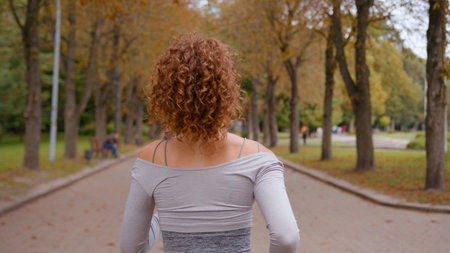 Sport outdoor in autumn park nature girl run back view from behind unrecognizable female woman athlete cardio exercise fit fitness runner running at morning training wellness marathon workout joggingの写真素材