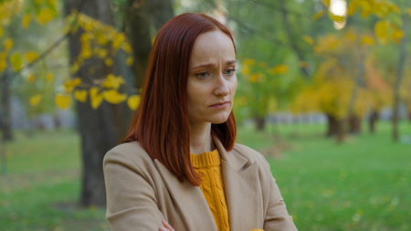 Pensive sad upset negative emotion thinking Caucasian woman girl female lady think pondering problem solution stress autumn park outside depression seasonal bad mood trouble date cancel frustratedの写真素材