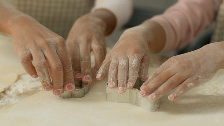 Close up dirty flour hands arms African American family mother mom woman female little girl daughter child kid cooking together kitchen cook teaching cookie mold cut out forms shapes cutter of doughの写真素材