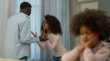 African American family problem quarrel conflict arguing parents angry man father male husband argue yelling screaming mad woman female mother domestic upset little child kid girl daughterの写真素材