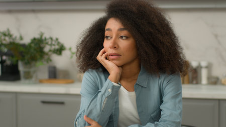 Alone sad upset African American unhappy woman biracial negative sadness mood girl lonely stress thinking boring pensive in home modern kitchen ethnic lady female suffer worried depressed melancholyの写真素材