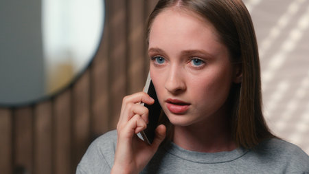 Emotional angry furious mad stressed Caucasian woman girl female lady annoyed at home bathroom talking cellphone aggressive nervous mobile phone call conversation problem shout talk quarrel conflictの写真素材