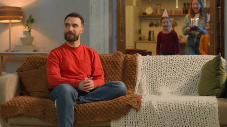 Happy birthday celebration at home Caucasian family mother children little girls congratulating father surprise celebrate birth party together joyful kids daughters parents blowing cake candles wishの写真素材