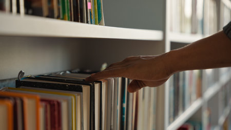 Close up hand African American man choose book bookshelf library bookstore student university unrecognizable reader literature textbooks literary bookworm bookcase education learn buyer shopper booksの写真素材