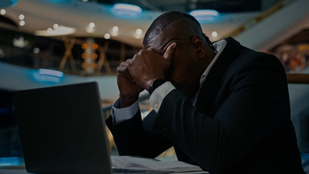 Middle-aged ethnic stressed worried man has problem with business papers error laptop trouble...