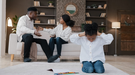 Sad little african daughter child kid girl closing ears upset at parents fighting arguing quarrel conflict at home stressed baby suffer from psychological trauma problem by divorce domestic violenceの写真素材