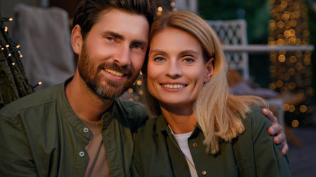 Portrait close up outside front view two people faces funny smiling happy Caucasian married couple newlyweds spouses bearded husband man and wife woman smile looking at camera outdoors in campingの写真素材