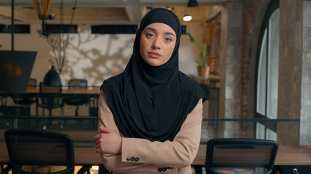 Islamic Indian lady boss worker manager lawyer manager in office posing with crossing hands. Muslim...