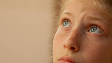 Close up little sad girl with blue eyes worried upset female face child Caucasian kid daughter schoolgirl sport athlete sportswoman gen z teen thinking bad mood offended primary school problemの写真素材