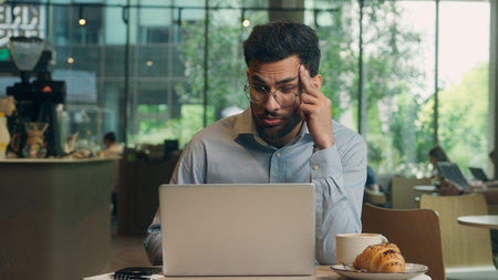 Sleepy tired bored overworked businessman Arabian Indian male business man exhausted guy upset sad...