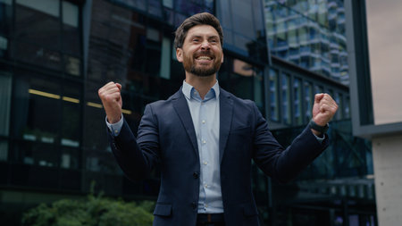 Excited businessman rich guy winner male entrepreneur happy business man investor celebrate success invest real estate triumph win amazing good news job offer hire celebration happiness city outdoorsの写真素材