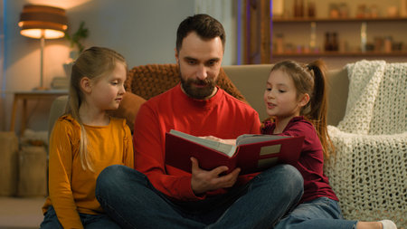 Caucasian family late night evening at home parent dad father man reading book kids watching photo...