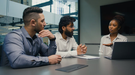 African American female businesswoman company CEO corporate mentor coach with laptop computer discuss startup service project software with multiethnic business team diverse men brainstorm in officeの写真素材