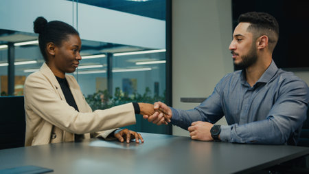 Executive employer HR manager salesman leader company man businessman talking with candidate woman businesswoman in office shake hand handshaking hiring agreementの写真素材