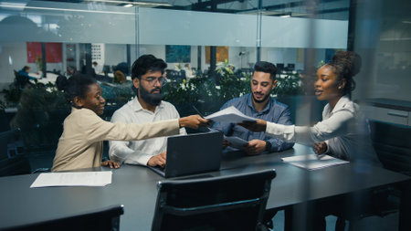 View from behind glass African American female team leader company CEO check strategy with diverse colleagues paperwork documents multiracial business people work project together at office teamworkの写真素材