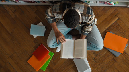 Top view African American man male guy unrecognizable student library bookshop bookshelf read pile...
