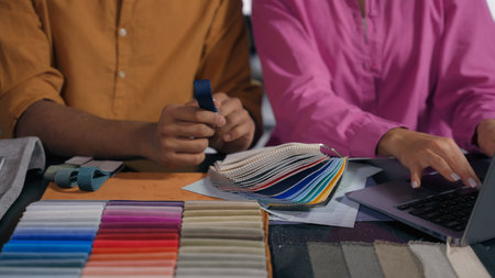 Male female hands touch choose color fabric samples collaborate fashion designers textile buying clothes online typing laptop unrecognizable woman man tailor dressmaker choosing cloth catalog on tableの写真素材