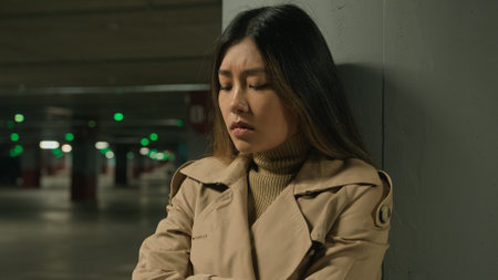 Upset anxious stressful Asian chinese woman female girl alone in car parking underground think difficult thoughts worried bad memories quarrel problem trouble suffer depression fatigue stress sorrowの写真素材