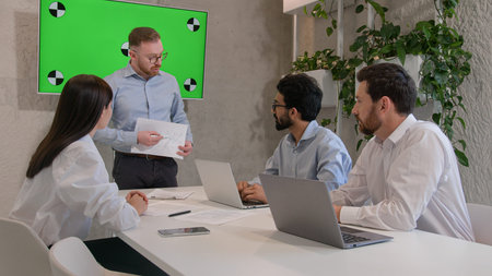 Office conference meeting with green chroma key screen male CEO leader talk to diverse multiracial...
