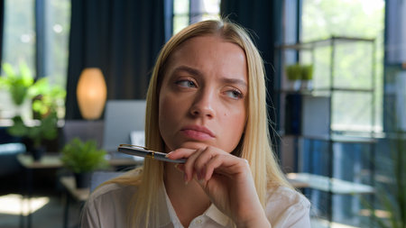 Portrait pensive doubtful tired Caucasian girl businesswoman female employer office worker young woman manager hold pen think business idea consider difficult question looking doubt unsure solve issueの写真素材