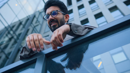 Arabian Indian man upset sad businessman sorrowful business employer on city balcony outside dismissed office worker lost job despair suffer problem failure bankruptcy stress difficulties bottom viewの写真素材