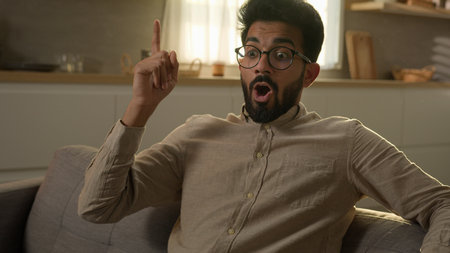 Arabian Indian homeowner man pensive thoughtful male think question ponder deep in thoughts dreaming creative brainstorming excited smart guy come up with idea happy insight gesture at home kitchenの写真素材