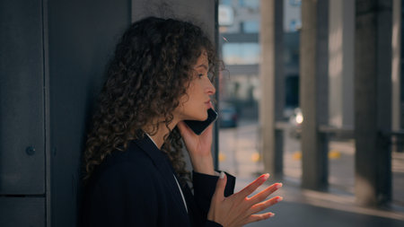 Annoyed anxious mad Caucasian businesswoman talking phone solve problem mobile conversation outdoors...