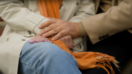 Close up holding hands old couple sit together outdoors two wrinkled palms male female partners elderly grandparents family retired man hand hug woman love old age support health care retirementの写真素材