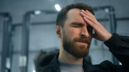 Close up Caucasian ill sick unwell man mechanic technical engineer automotive industry worker working hard at auto car truck service suffer headache feeling bad migraine overworked painful head acheの写真素材