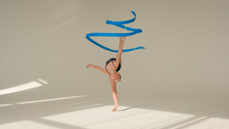 Caucasian woman schoolgirl kid daughter child little girl artistic female ballet dancer sportswoman young athlete teenager gymnast spinning dancing with tape sport gymnastics dance studio choreographyの写真素材