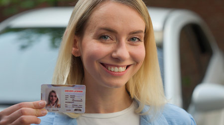 Joyful Caucasian businesswoman girl close up smiling hold driver license id certificate in city female automobile owner showing document driving school student exam woman buying auto renting vehicleの写真素材