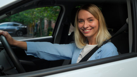 Happy Caucasian businesswoman female woman in car automobile owner seat belt safety girl driver smile demonstrating thumb up in city ride driving test drive auto renting transport buy vehicleの写真素材